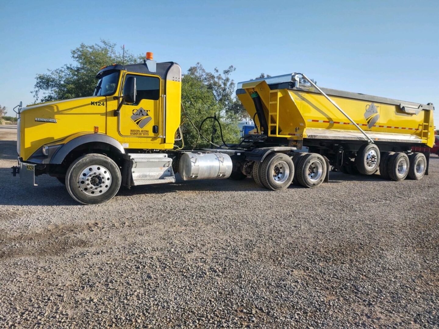 a yellow CAT truck with a trailer